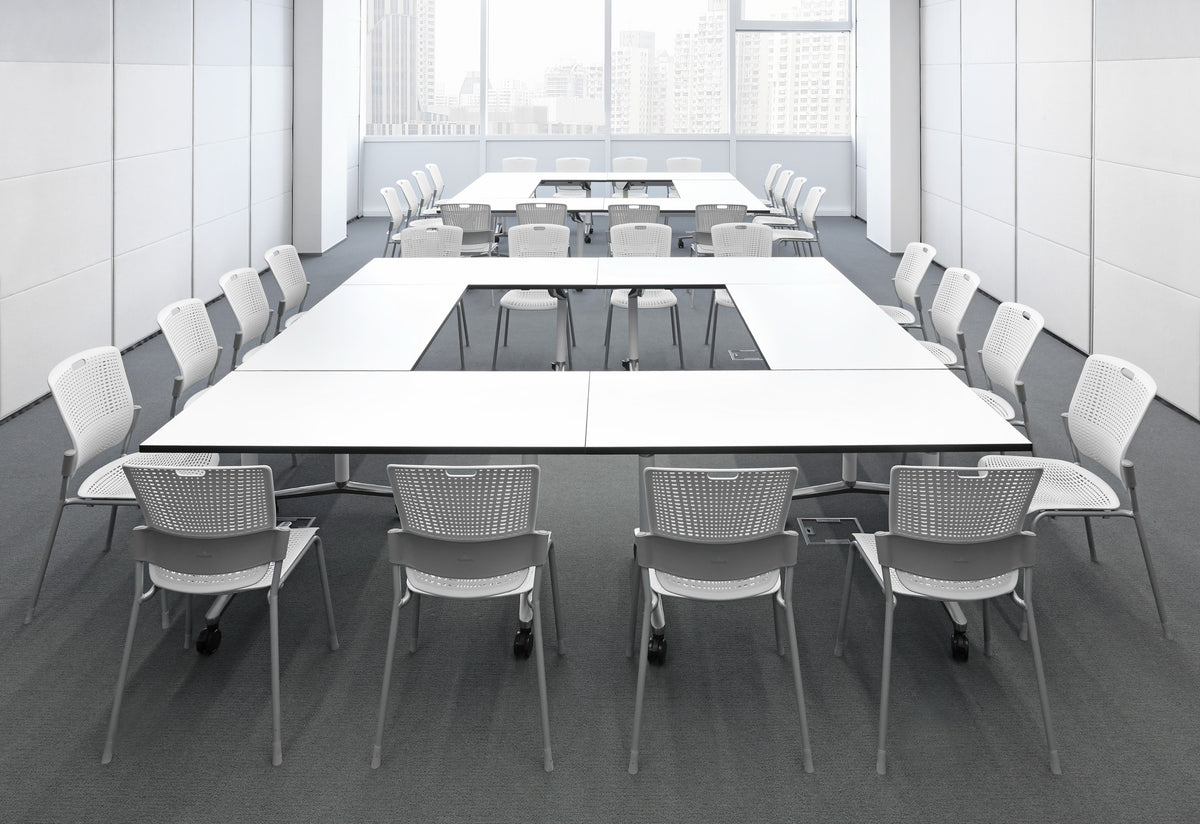 White Humanscale Cinto armless stackable chairs with silver bases arranged around large white conference tables in a modern office with city views